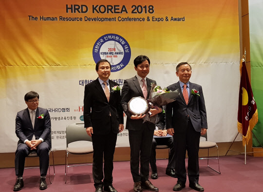 에스원은 한국HRD협회가 주최한 '2018 대한민국 인적자원개발대상'에서 종합대상을 받았다고 21일 밝혔다. 이 회사는 바이크스쿨 등 실습 위주의 교육과 체계적인 분야별 전문가 양성 프로그램 등에 대해 높은 평가를 받았다. 송대곤 에스원 인재개발원 부원장(가운데)이 협회 관계자와 기념촬영을 하고 있다.  에스원 제공